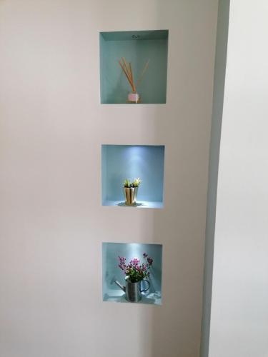 a wall with three shelves with flowers in them at Wild Atlantic Lodge Bed & Breakfast in Lahinch