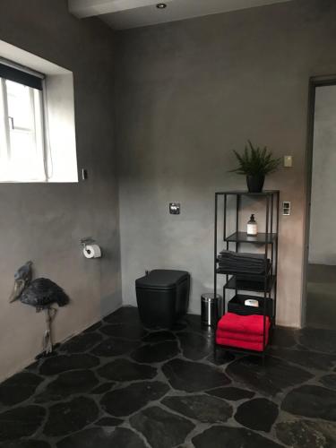 a room with a ostrich and a red stool in it at Tórhús in Miðvágur