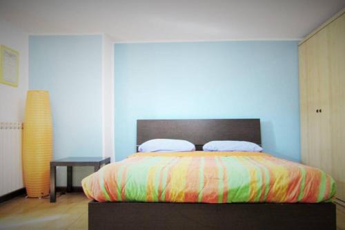 una camera da letto con un grande letto con una coperta colorata di Sky Sunset a Milano