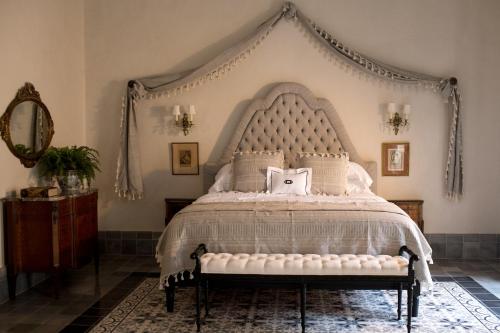 a bedroom with a large bed with a white canopy at Casa Olivia in Mérida