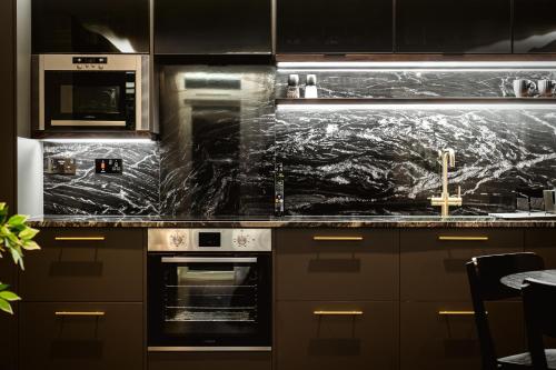 a kitchen with a marble counter top with a stove at The Acacia, Luxury with Private Balcony + Parking in Leicester