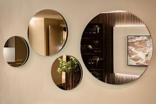 three mirrors on a wall in a bathroom at The Acacia, Luxury with Private Balcony + Parking in Leicester