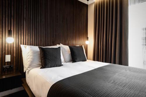 a bedroom with a large bed with black and white pillows at The Acacia, Luxury with Private Balcony + Parking in Leicester