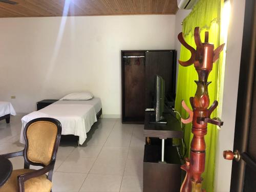 Zimmer mit einem Schlafzimmer mit einem Bett und einem TV in der Unterkunft Hotel El Lago 