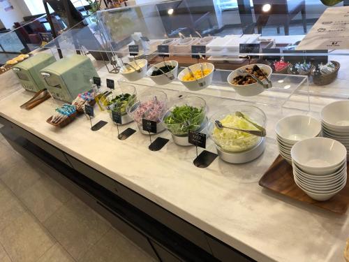 una línea de buffet con tazones y platos de comida en Via Inn Nagoya Station Tsubaki-cho en Nagoya