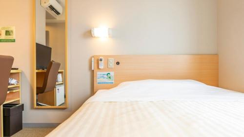 Habitación hospitalaria con cama y espejo en Super Hotel Ueno-Okachimachi, en Tokio