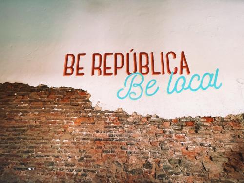 a sign on the side of a brick wall at Republica Hostel Santa Marta in Santa Marta