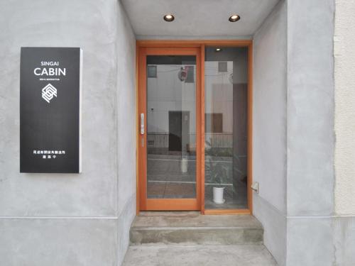 a glass door of a building with a sign on it at SINGAI CABIN in Onomichi