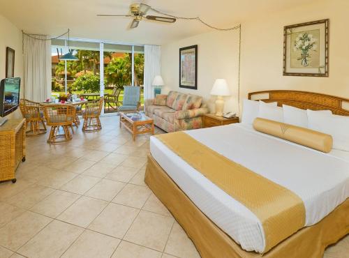 a hotel room with two beds and a table at Aston Maui Kaanapali Villas in Lahaina