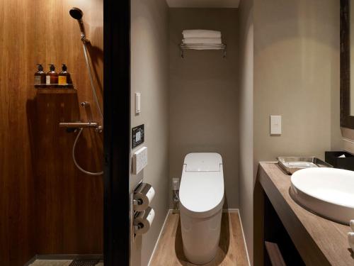 a bathroom with a toilet and a sink at Granbell hotel Tanuki, Sapporo in Sapporo