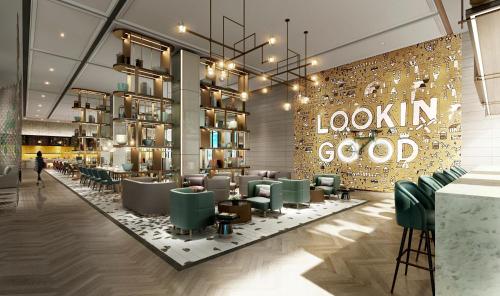 a restaurant with a lobby with green chairs and a sign at Holiday Inn Fuyang by IHG in Fuyang