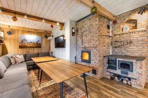 a living room with a wooden table and a brick fireplace at Soomaa Puhkeküla in Riisa