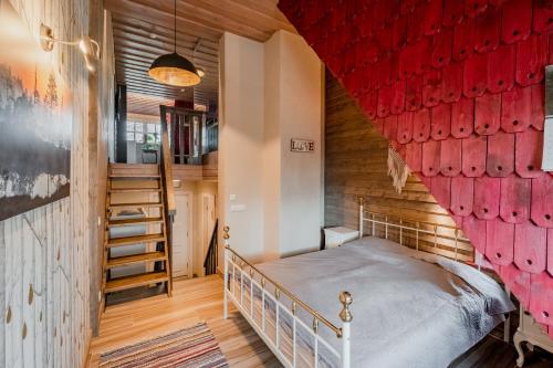 a bedroom with a bed with a red wall at Soomaa Puhkeküla in Riisa