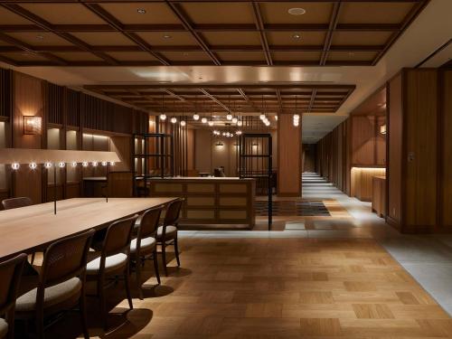 a lobby with a long table and chairs at Granbell hotel Tanuki, Sapporo in Sapporo