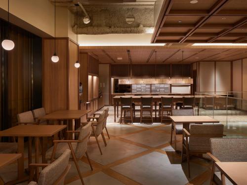a restaurant with tables and chairs and a bar at Granbell hotel Tanuki, Sapporo in Sapporo