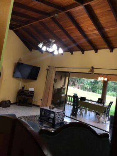 a living room with a couch and a table and a television at Linda casa de verano con amplias zonas verdes in San Isidro
