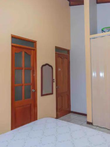 a bedroom with two wooden doors and a mirror at Linda casa de verano con amplias zonas verdes in San Isidro
