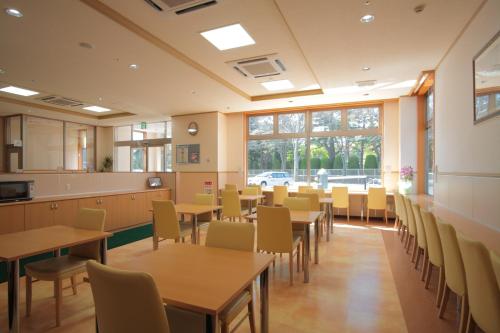 a classroom with tables and chairs in a cafeteria at Life Inn Katsuta Station West in Hitachinaka