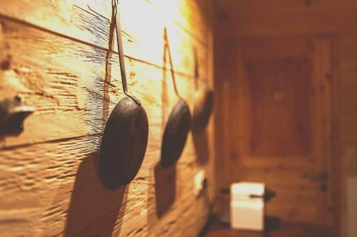 a wooden wall with utensils hanging on it at Stodingerhütte in Winkl