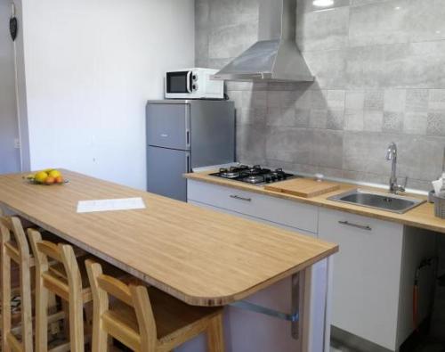 a kitchen with a counter and a sink and a stove at La Fragua del Canajal apartamentos in San Cosme