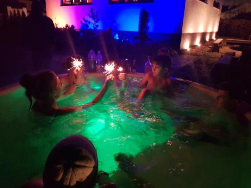 a group of children playing in a swimming pool with sparklers at Ostravice Apartment in Ostravice