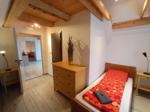 a bedroom with a bed and a dresser and a room at Tiptop Apartment & Outdoor Activities in Bovec