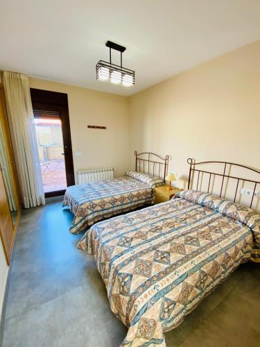 a room with two beds and a window at La choza de Nolasco in Valdeganga