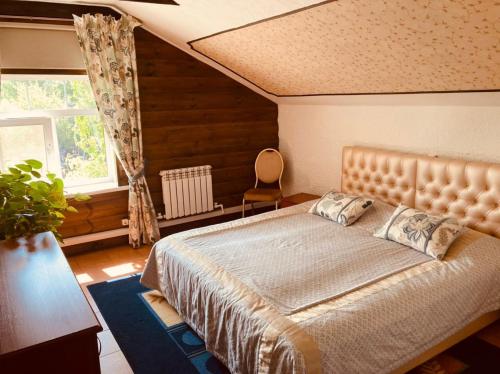Un dormitorio con una cama grande y una ventana en Fishing and hunting hotel Alexandrovsky Prichal, en Ves'yegonsk