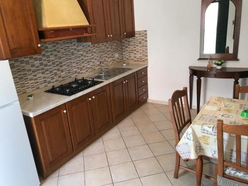 a kitchen with a sink and a stove and a table at Il Cremino in Tropea