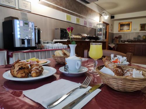 a table with plates of food and baskets of bread at Hotel Carignano in Lucca