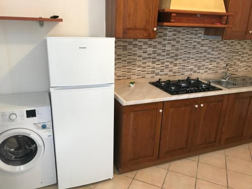 a kitchen with a white refrigerator and a washing machine at Il Cremino in Tropea