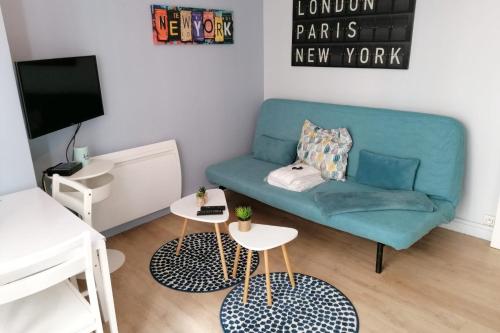 un salon avec un canapé bleu et deux tables dans l'établissement #J7 The Maginot Caserne de Bonne, à Grenoble