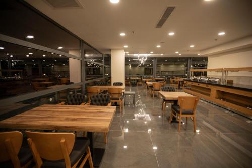 a dining room with wooden tables and chairs at Divares Luxury Hotel in Gaziantep