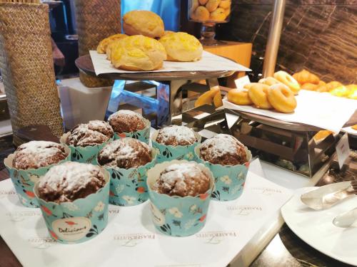 a table with muffins and donuts on a table at Fraser Suites Shenzhen, Near Huaqiang North Business Zone, Infinity pool, Offer 1 free breakfast in Shenzhen