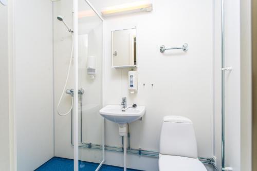a bathroom with a shower and a sink and a toilet at Easy Home Apartments in Hammerfest