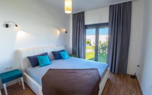 Un dormitorio con una cama con almohadas azules y una ventana en Luxury Villa in Mostar en Mostar