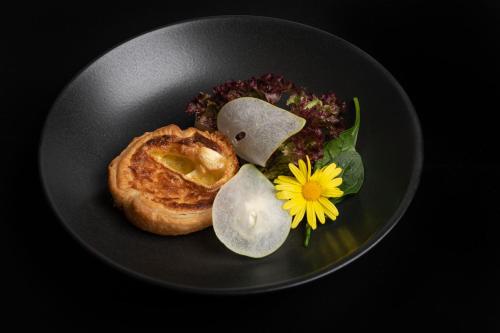 a plate of food with a sandwich and a flower at Hotel Crusch Alba Zernez in Zernez