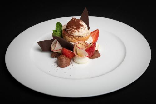 a plate of food with ice cream and fruit at Hotel Crusch Alba Zernez in Zernez