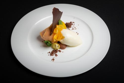 a white plate with an egg and some food at Hotel Crusch Alba Zernez in Zernez