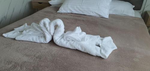 a pile of white towels on a bed at Bellhaven Park in Heatherbrae
