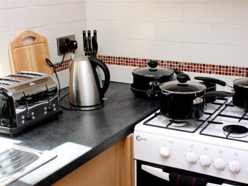 a kitchen with a stove with pots and pans on it at Rooms at The Nook in Holmfirth