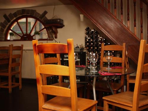 霍姆弗斯的住宿－Rooms at The Nook，用餐室配有桌椅和葡萄酒瓶