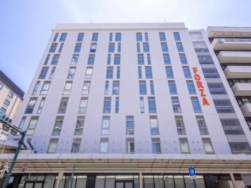 a tall white building with a sign on it at Hotel Forza Kyoto Shijo Kawaramachi in Kyoto