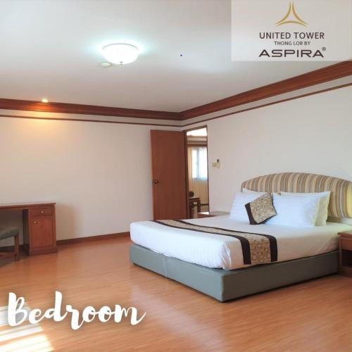 a bedroom with a bed and a desk and a television at United Tower Thonglor by Aspira in Bangkok