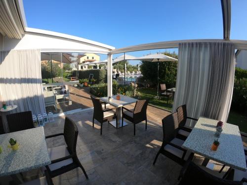 a patio with tables and chairs and a view of a yard at Villa Badi in Umag