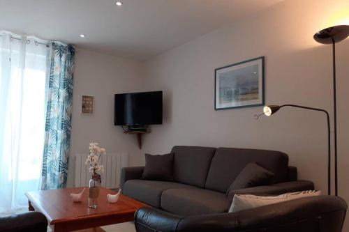 a living room with a couch and a coffee table at appartement 4 pers dans longère à 800m de la plage in Plouhinec