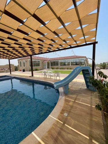 a swimming pool with a slide and a playground at Alreef farm in Ras al Khaimah