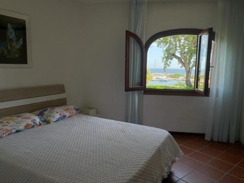 ein Schlafzimmer mit einem Bett und einem offenen Fenster in der Unterkunft Casa Francesca Puntaldia in San Teodoro