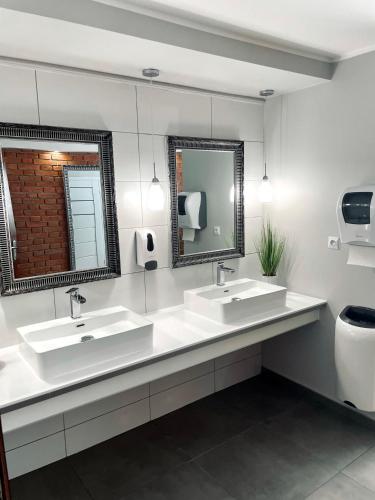 a bathroom with two sinks and a toilet and a mirror at Przystań Biskupińska in Biskupin