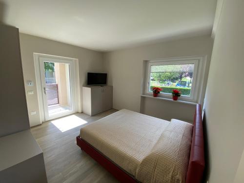 a bedroom with a bed and two windows at Chaligne Suite in Aosta